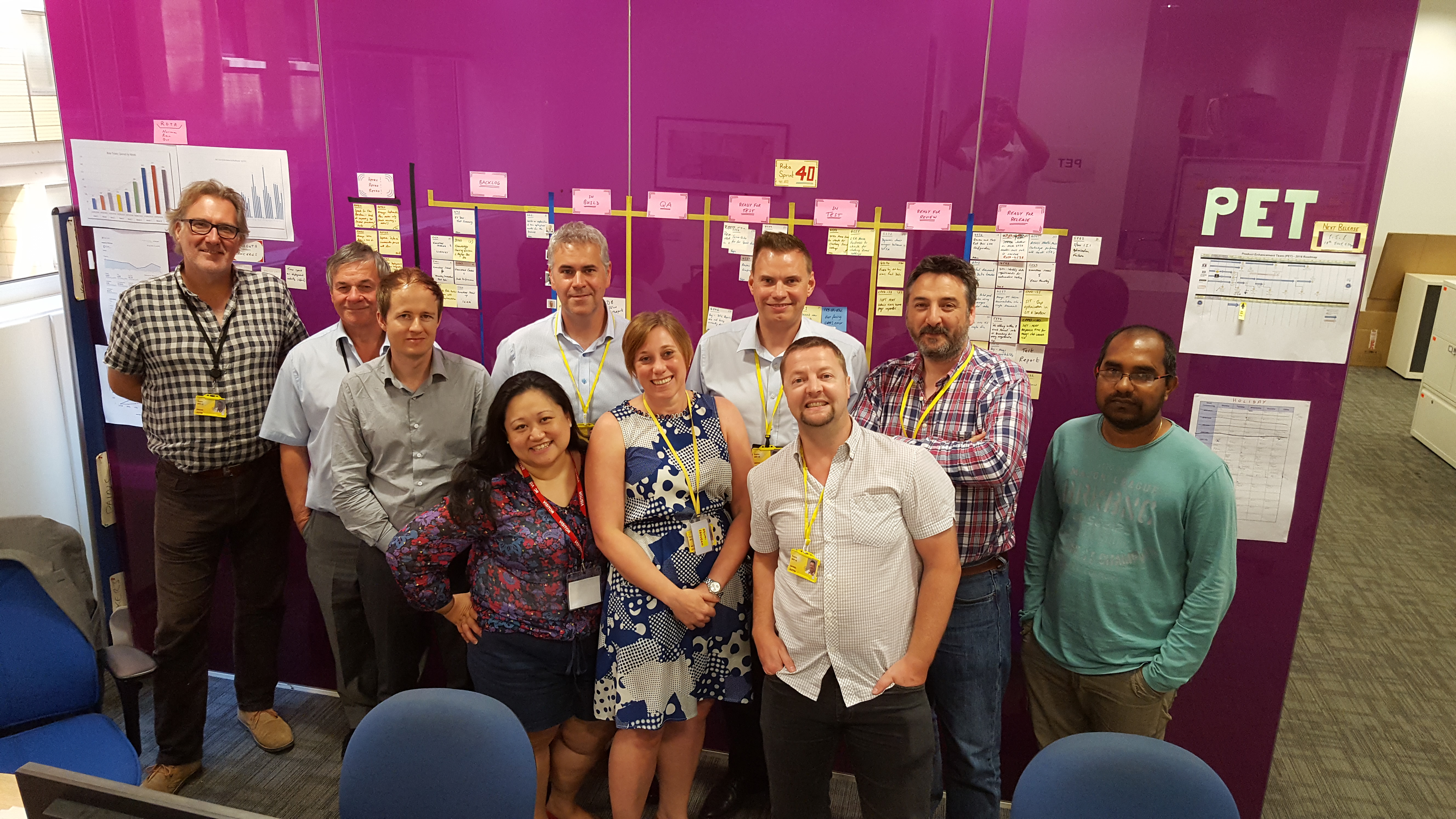 group of people standing in front of purple wall