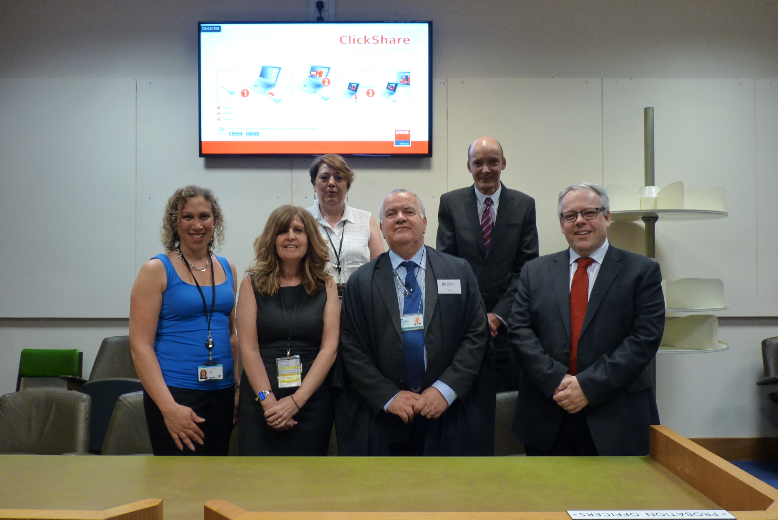 Group of people standing in front of plasma screen