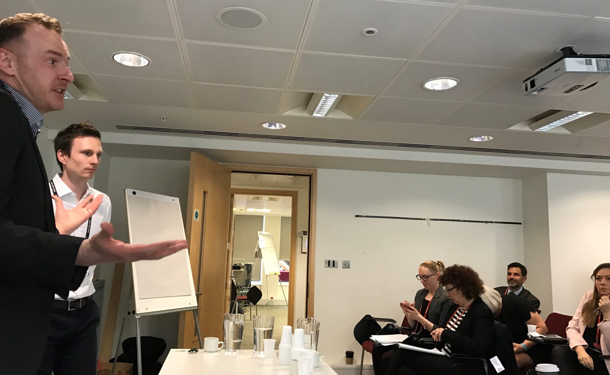 Man standing at table giving a presentation.