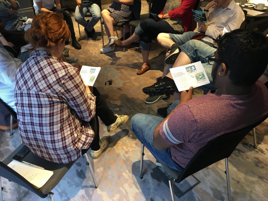 People sitting down on chairs reading leaflets with open justice statements