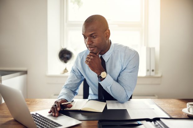 Man sitting by a laptop at a desk