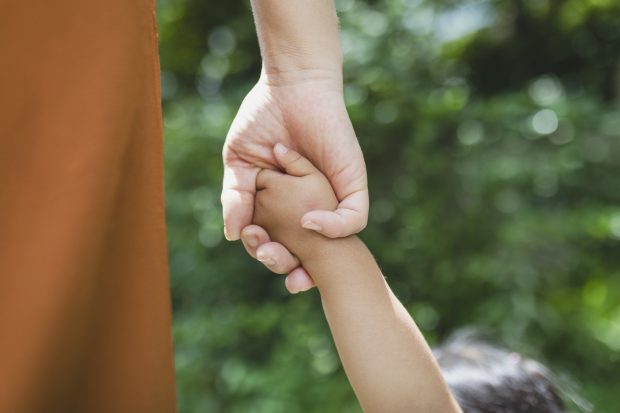 Mother and daughter holding each other's hands in the park