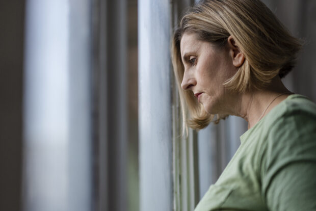 A close up side view of a woman having a quiet moment of reflection.