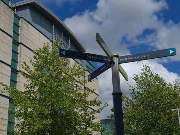 Signpost displaying directions to court buildings in Northern Ireland.