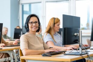 Smiling call centre worker at desk